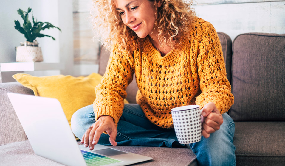 women at computer with cup