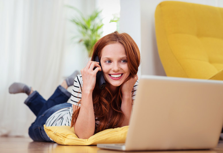 woman on floor with phone & computer