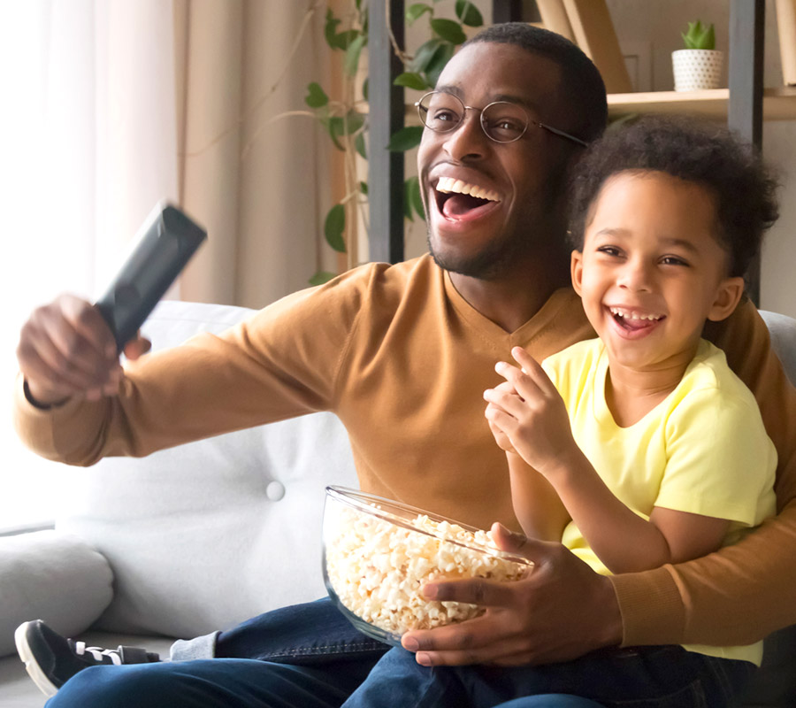 man and child with remote & popcorn