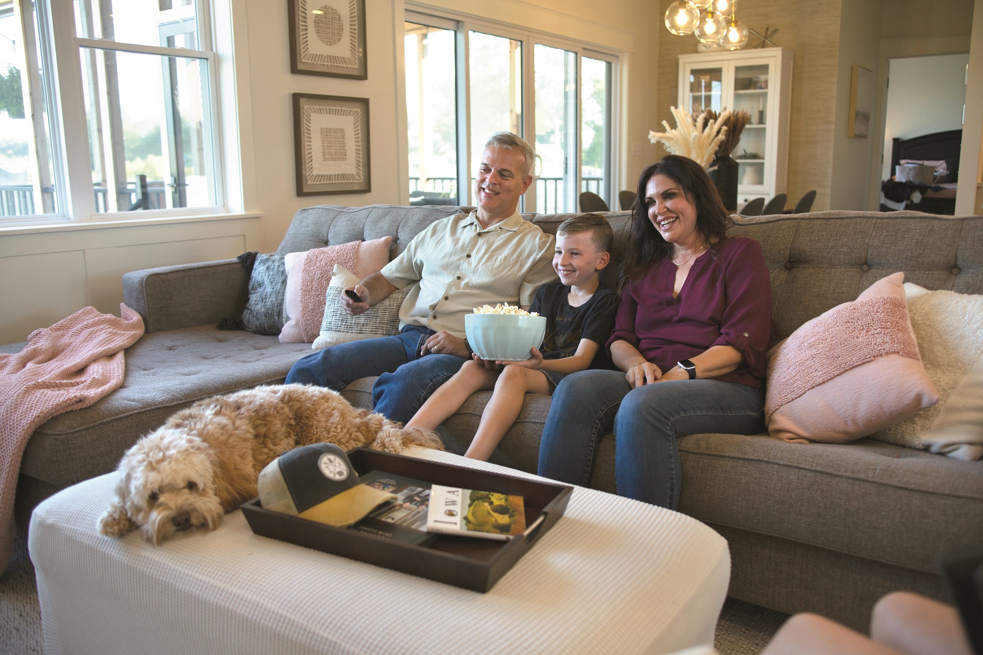 family on couch with popcorn and dog
